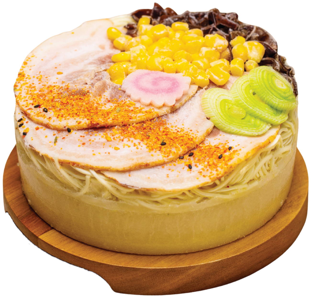 A frozen ramen cake on a wooden board: a broth base, a layer of noodles, then char siu, sweetcorn, fish cake and leek on top.